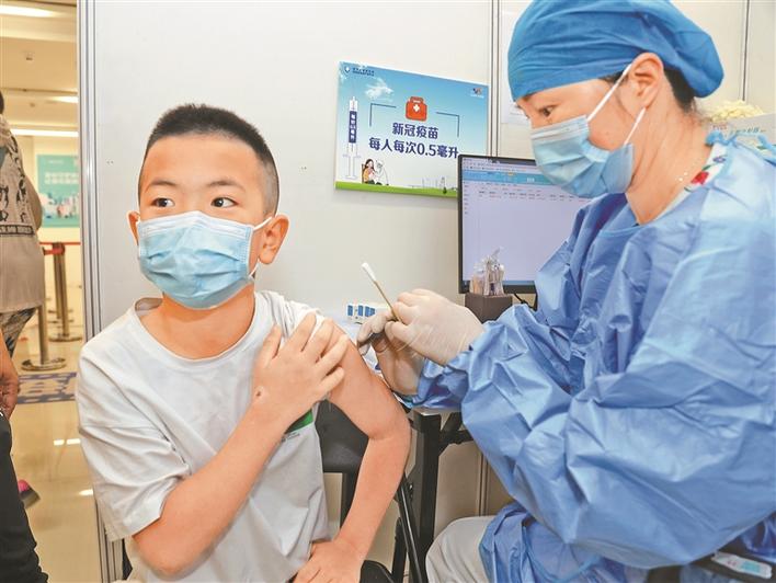 小朋友在家长陪护下接种新冠病毒疫苗.