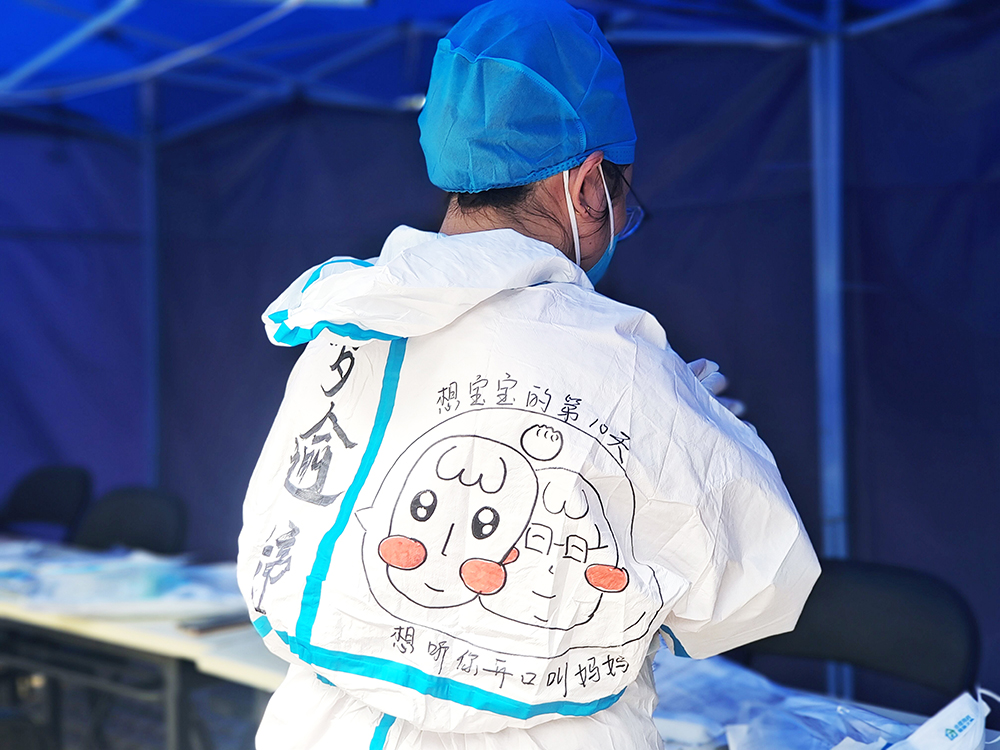 罗逾婷把对丈夫和孩子的思念写在防护服上。消息报融媒体记者 戴妩頔 摄.jpg