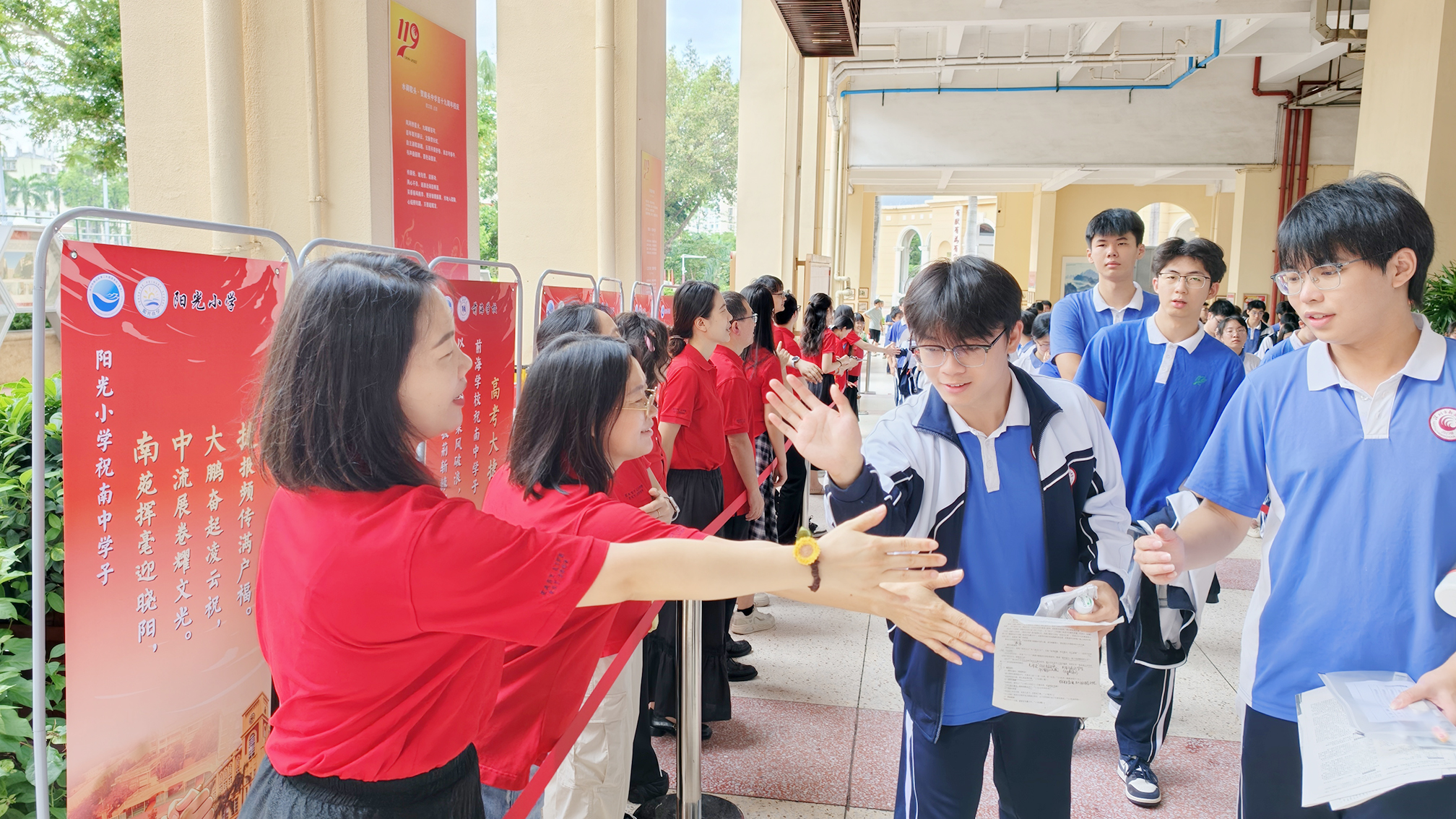 南头中学教师与考生击掌,为其加油鼓劲。学校供图.jpg